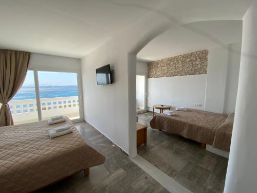 提诺斯Aeolos Bay Tinos的酒店客房设有两张床和一个阳台。