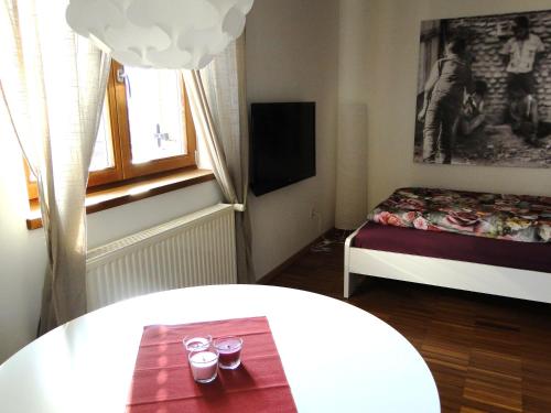 纳图尔诺Gemütliche Einzimmerwohnung mit Parkgarage的小房间设有床和带眼镜的桌子