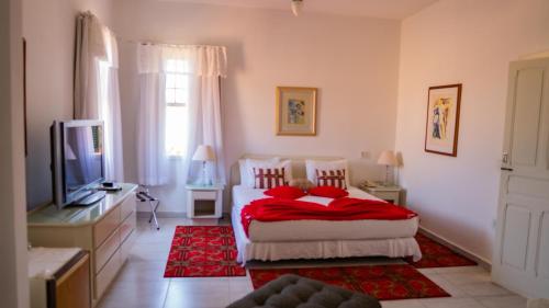 克拉鲁河畔卡尔穆Varandas da Montanha的一间卧室配有两张床和电视。