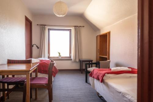 维比维比库鲁酒店的客房设有两张床、一张桌子和一扇窗户。