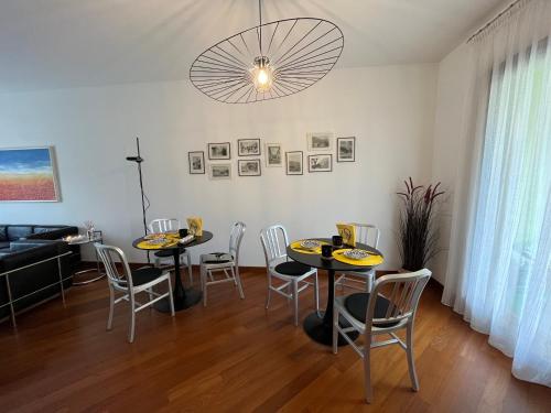 阿巴迪亚拉里亚纳Miss Scola Pastry Rooms - Lake Como的一间带2张桌子和椅子的用餐室以及吊灯