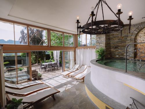 TassulloRelais Villa Quercia的房屋设有1个带椅子和吊灯的游泳池