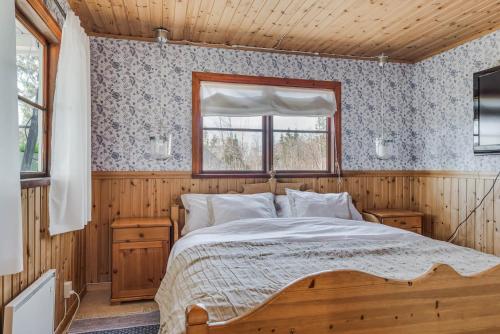 DekarsönGuesthouse on an Island的木制客房内的一间卧室,配有一张床