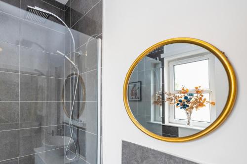 皮布尔斯Cosy town centre cottage的浴室设有金色镜子和水槽