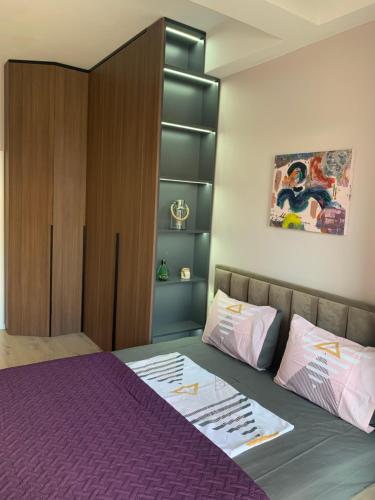 地拉那Lovely 1-bedroom Condo in Tirana WiFi-Netflix-AC的一间卧室配有一张紫色的床和一个橱柜