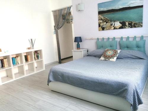 切齐纳码头Bilocale piano terra Marina di Cecina的卧室配有一张床,墙上挂有绘画作品