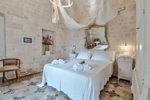 奇斯泰尼诺Borgo Altobello的卧室配有白色的床和镜子