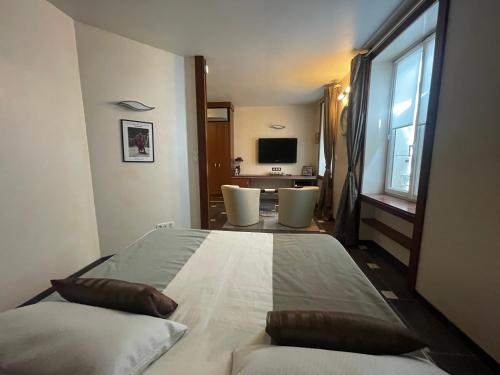 奥朗日Véritable Suite d'Hotel!的一间卧室配有一张带两把椅子的床和电视。