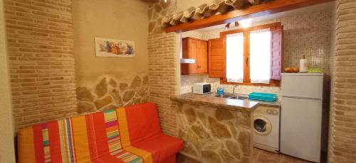 埃尔切德拉谢拉Casa Camille.Villares Elche de la Sierra的厨房配有冰箱和椅子