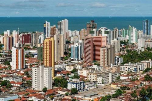 若昂佩索阿Quarto Individual para 3 Pessoas em AP Compartilhado的一座拥有高楼和海洋的大城市