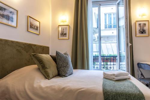 巴黎Montmartre Apartments Chagall的一间卧室设有一张大床和大窗户