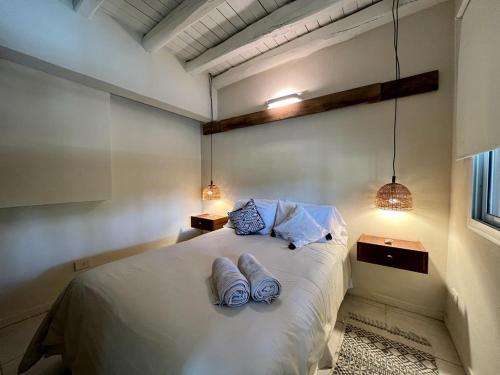 查克拉斯德科里亚La Posadita de Chacras的卧室配有一张带两个枕头的大白色床
