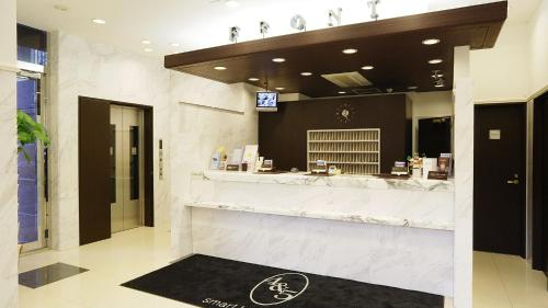 东京Toyoko Inn Tokyo Nihombashi Hamacho Meijiza Mae的酒店大堂的酒吧,带柜台