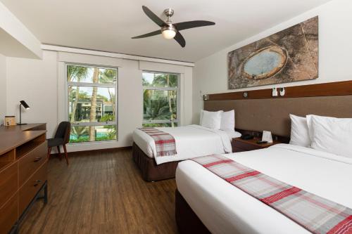 皮乌拉皮乌拉安迪纳优质酒店的酒店客房配有两张床和吊扇。