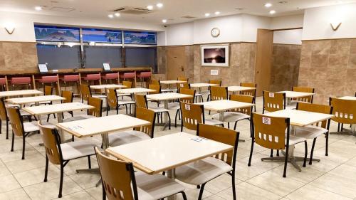 东京东横INN-新宿歌舞伎町的空的饭厅,配有桌椅
