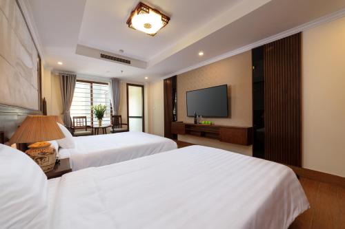 河内The West Hotel & Spa的酒店客房设有两张床和一台平面电视。
