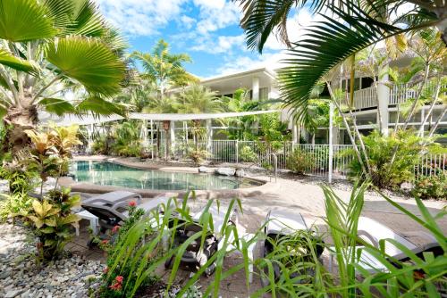 道格拉斯港Tropical Nites Holiday Townhouses的一个带游泳池和棕榈树的度假村
