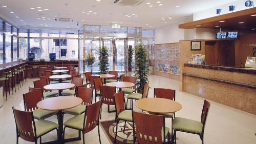 东京Toyoko Inn Tokyo Shinagawa Oimachi的一间带桌椅的餐厅和一间酒吧