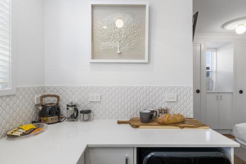 萨维特尔Sea Pine Studio的厨房配有白色台面,墙上挂着一幅画