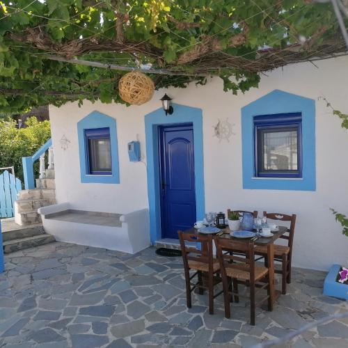 阿彻奇洛斯Sea Breeze的一张桌子和椅子,位于一栋带蓝色门的房子前