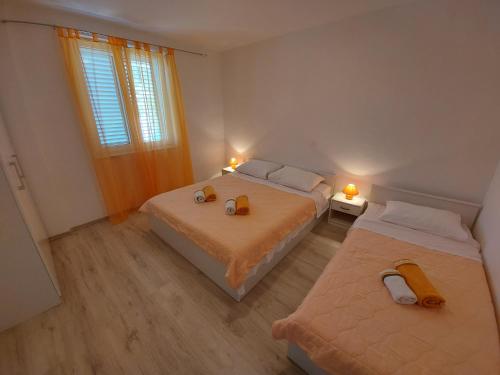 Draga BašćanskaApartments Marija的一间卧室设有两张床和窗户。