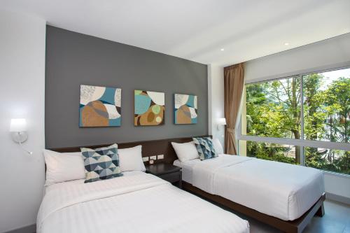卡伦海滩Happy Apartment on Karon Beach的带窗户的客房内的两张床
