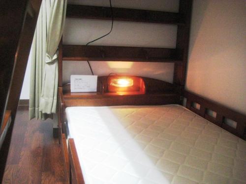 屋久岛愉凯纳卡玛塔奇旅馆的一张小床,上面有灯
