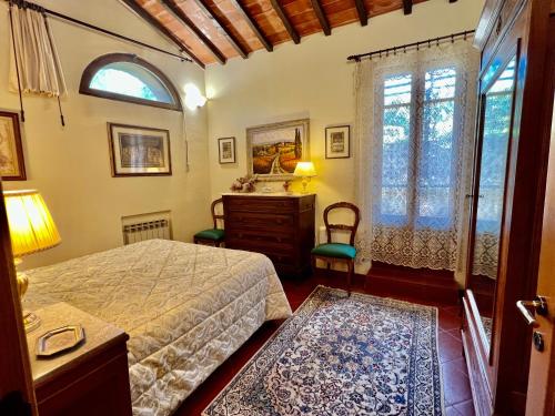 蒙特里久尼Monteriggioni Castello的一间卧室配有一张床、一个梳妆台和一扇窗户。