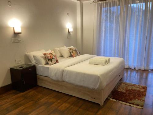 PedongMiknaon Farm Stay的卧室配有一张带白色床单和枕头的大床。