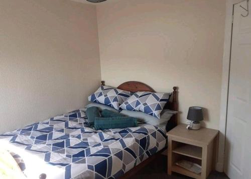 坎贝尔城Inviting 1-Bed Apartment in Campbeltown Loch views的卧室配有蓝色和白色的床和一张桌子