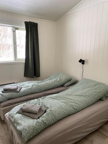 OlsborgHøgtun kulturklynge的两张睡床彼此相邻,位于一个房间里