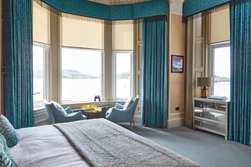 奥本No17 The Promenade的一间卧室配有蓝色窗帘、一张床和一张桌子及椅子