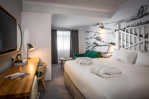 彭里斯北湖Spa酒店的酒店客房设有一张白色大床和一张书桌