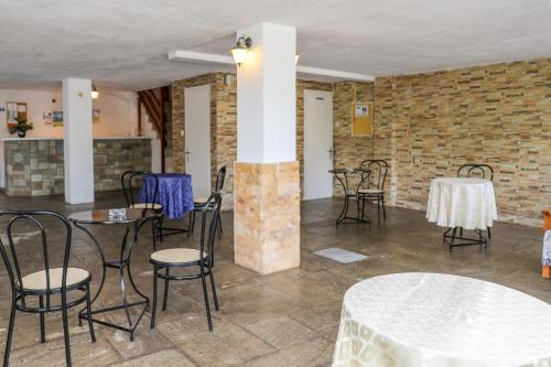 斯科派洛斯Hotel Aggeliki的配有桌椅的房间和砖墙