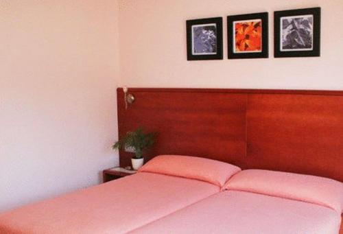 圣基里科-德贝索拉桑特基尔塞德韦索拉酒店的卧室配有红色的床,墙上挂有两张照片