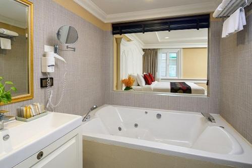 曼谷Kingston Suites Bangkok的一间带大浴缸和大镜子的浴室