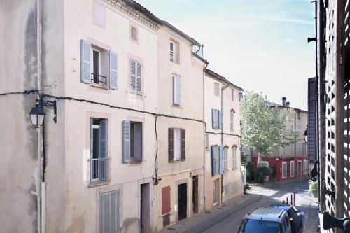 Montfort-sur-ArgensLa Cachette du Comte的街上有蓝色百叶窗的古老建筑