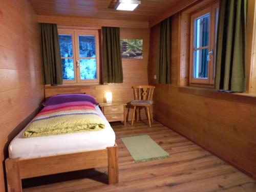 瓦尔德阿尔贝格Ferienwohnung Stelzis的一间小卧室,配有一张床和一把椅子