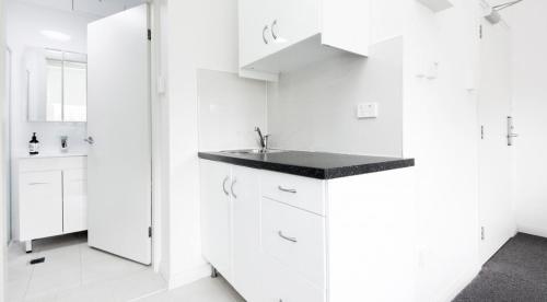 悉尼Excelsior Apartments at Glebe的白色的厨房配有白色橱柜和水槽