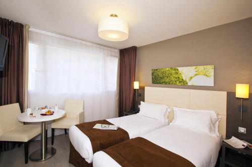 蒙特勒伊塞祖尔阿菲尔蒙特利尔圣曼德酒店的酒店客房设有两张床和一张桌子。
