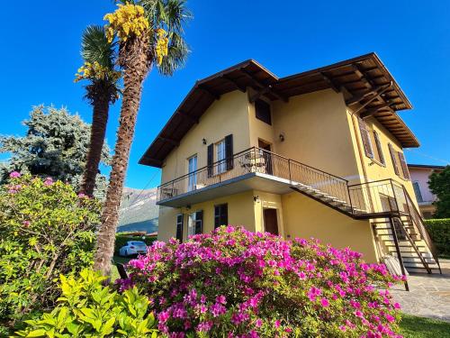 贝拉吉奥粉红之家公寓酒店的棕榈树和鲜花的房子