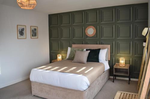 威森肖Maya Boutique Inn - Garden - Sleeps 6的一间卧室设有一张大床和绿色的墙壁