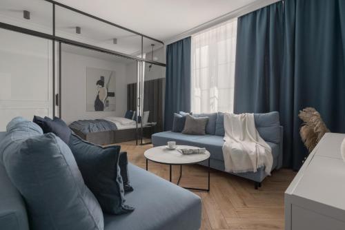 卡托维兹APARTIO ROOMS Katowice的客厅配有蓝色的沙发和床。