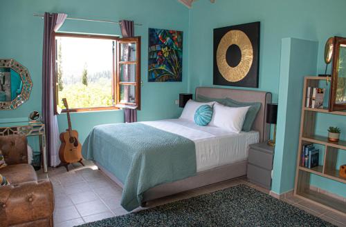 Áno KorakiánaThe Little House Corfu的一间卧室设有一张床、一个窗口和吉他