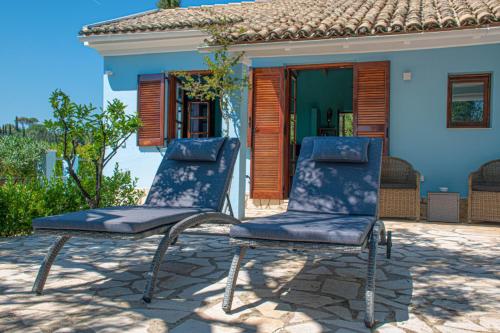 Áno KorakiánaThe Little House Corfu的两把椅子坐在房子前面的庭院