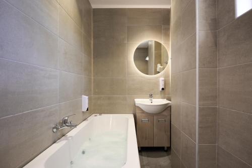 普拉基亚斯Afroditi Hotel的带浴缸、水槽和镜子的浴室