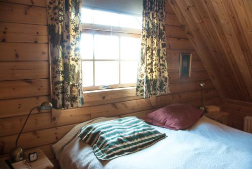 SkeljabrekkaVindheimar Cottage - Great View - Hot Tub的一间卧室配有床和带窗帘的窗户