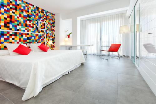 德尼亚维拉莫尔酒店的一间卧室设有一张大床和色彩缤纷的墙壁
