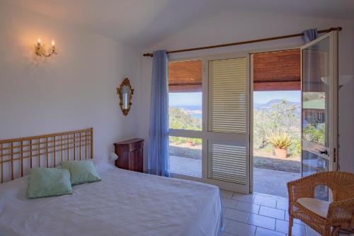 费拉约港HelloElba Villetta Azzurra的一间卧室设有一张床和一个大窗户