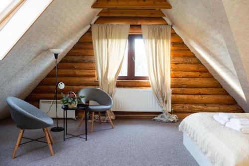PadureHunter's Lodge的一间卧室配有一张床、两把椅子和一张桌子